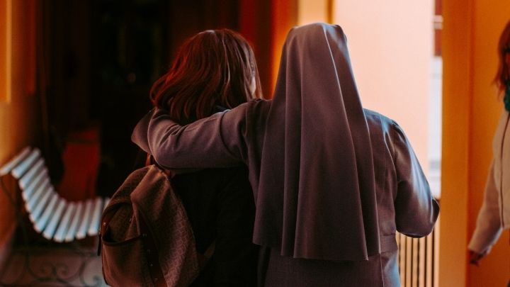 Une religieuse tient une jeune femme par l'épaule